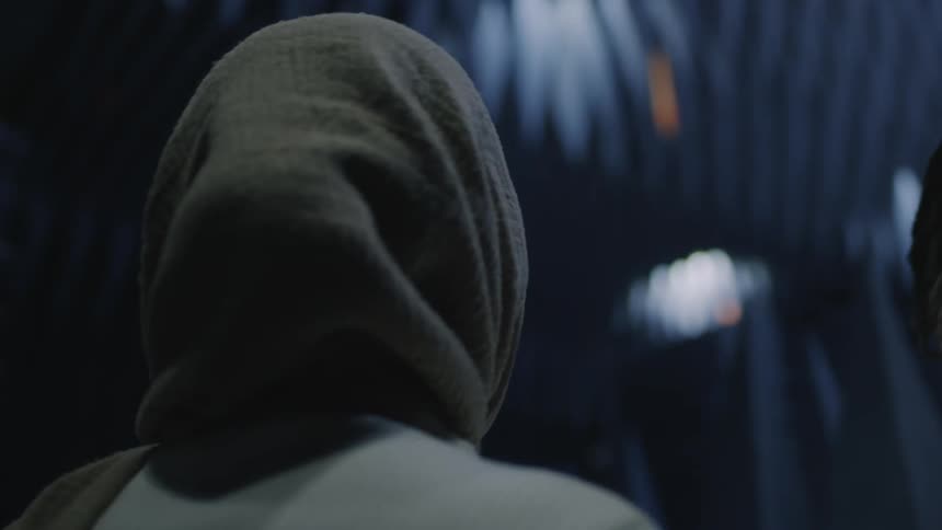 Woman wearing a hijab looking around next to another woman
