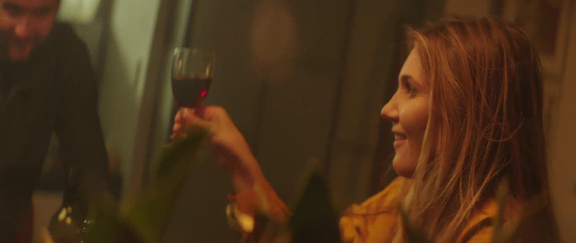 Blonde woman drinking wine and toasting with friends