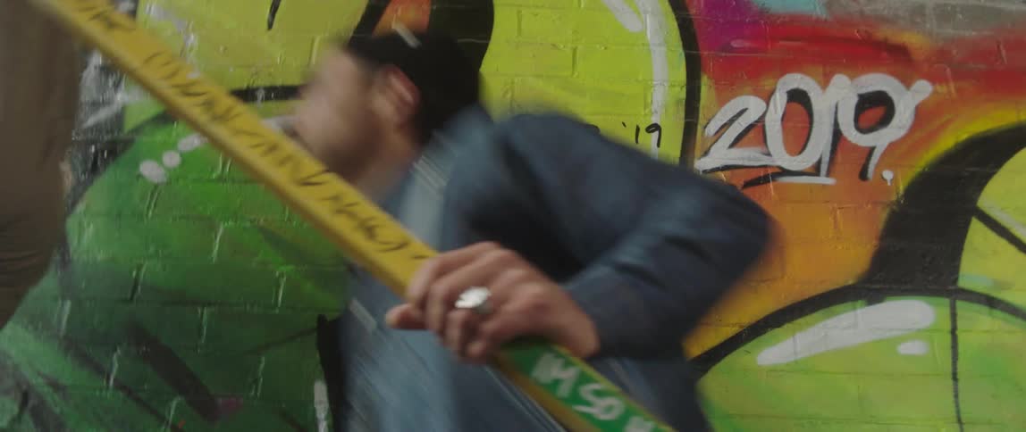 Young man and woman happily climbing the stairs of an abandoned building with colorful graffiti on its walls