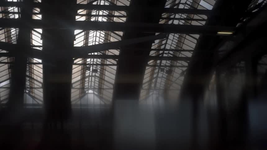 Passing through a train station looking at the rafters of the building