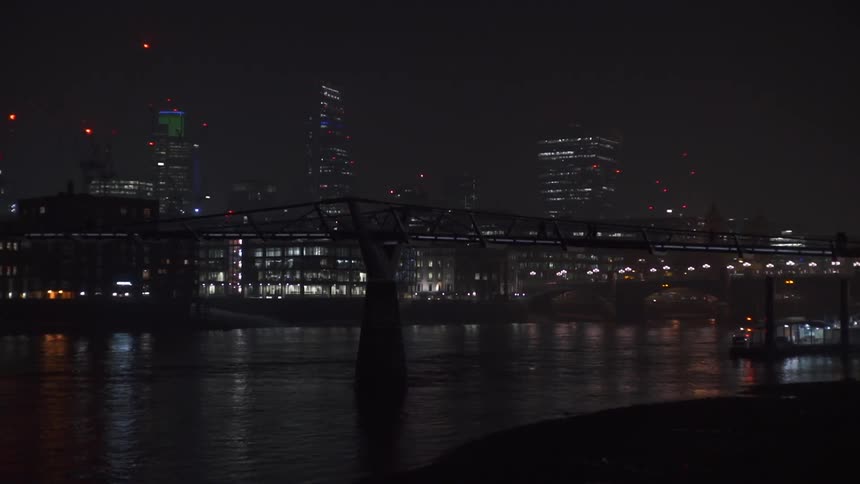 The water leads to a lit city at night