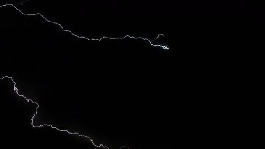 Lightning spreads through dark storm clouds at night