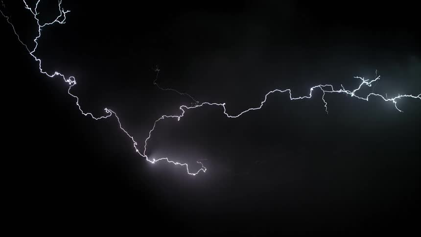 Bolts of lightning spread across a dark and cloudy sky at night