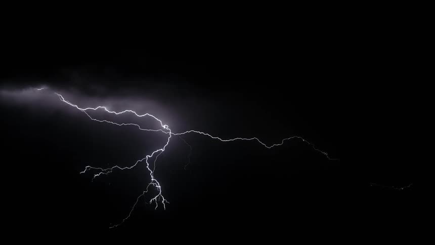 A lightning storm in the middle of the night flashing across the sky and lighting it up