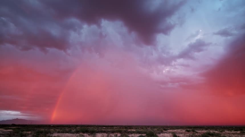 Lightning flashes within storm clouds that are releasing tons of rain
