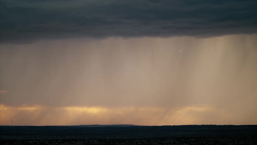 A lightning and rain storm covering flatland over a wide open landscape