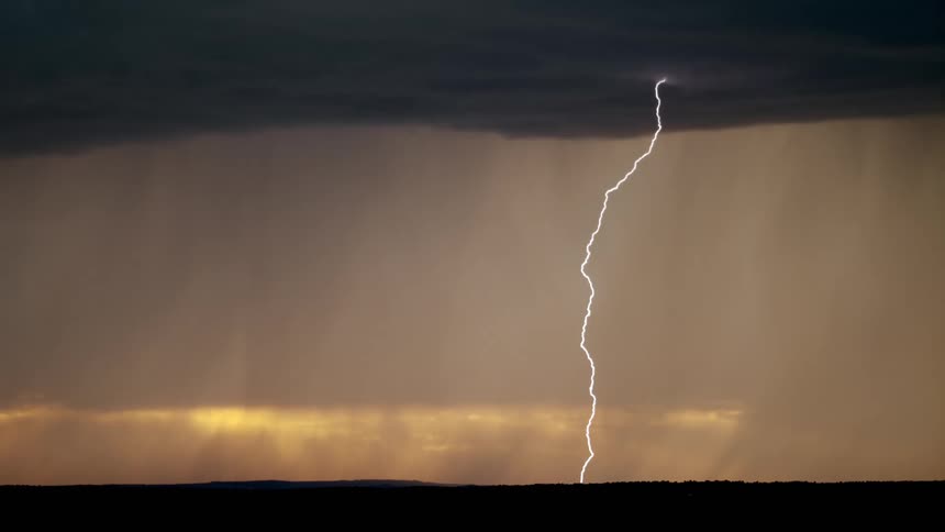 A huge beam of lightning stretching across the sky and falling to the ground on a stormy day with black clouds