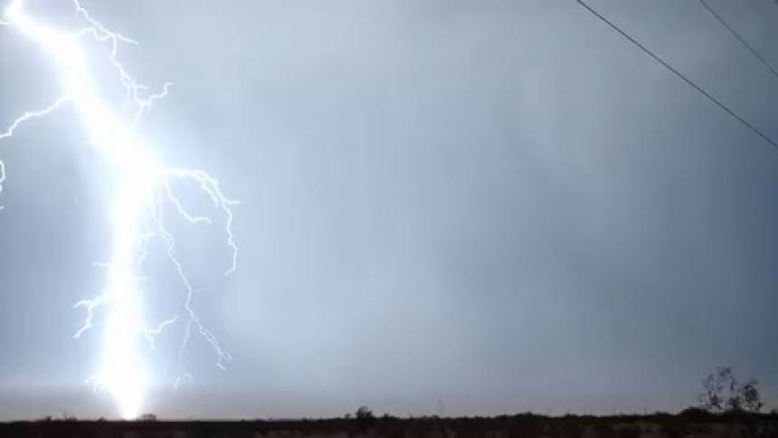 In the cold night the lightning strike reveal the electric lines through the valley