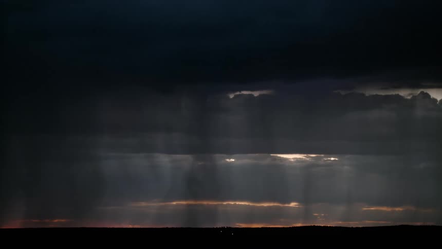 Lightning lighting up the sky and striking down on a wide open valley during a cloudy gray storm