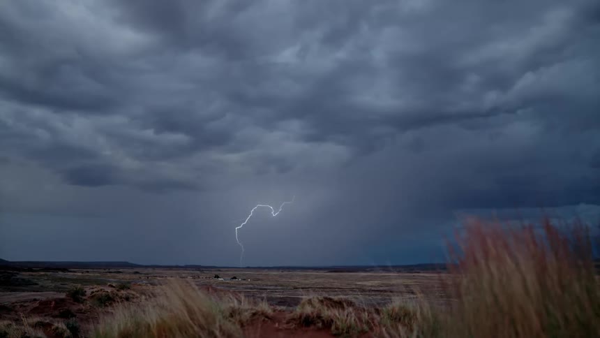 Thunder cracking the cloudy sky and mountains in the distance