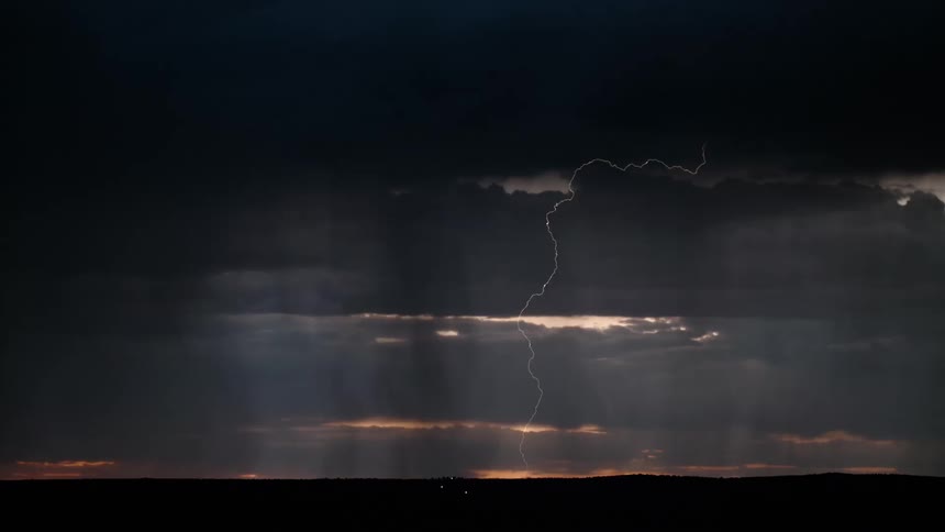 Thunder with white lights cutting through the cloudy sky at dusk