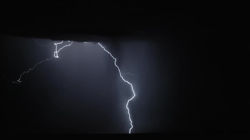 A series of lightning strikes illuminate the sky in the middle of the night