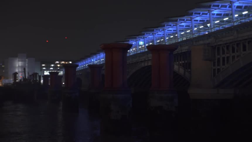 A bridge is lit up with blue lights at night