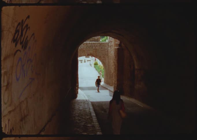 A man and woman walk towards one another as they walk through a tunnel
