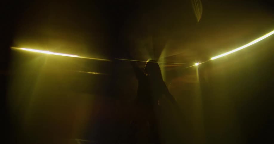 A female dancer is dancing on the dance floor amidst the party flashing screen led lights