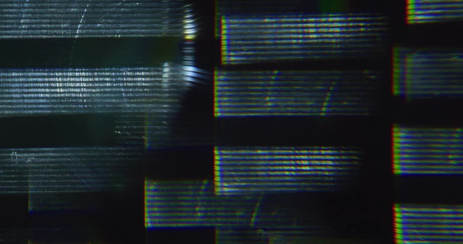 Rectangles of light move up a dark surfaced wall with textured lines