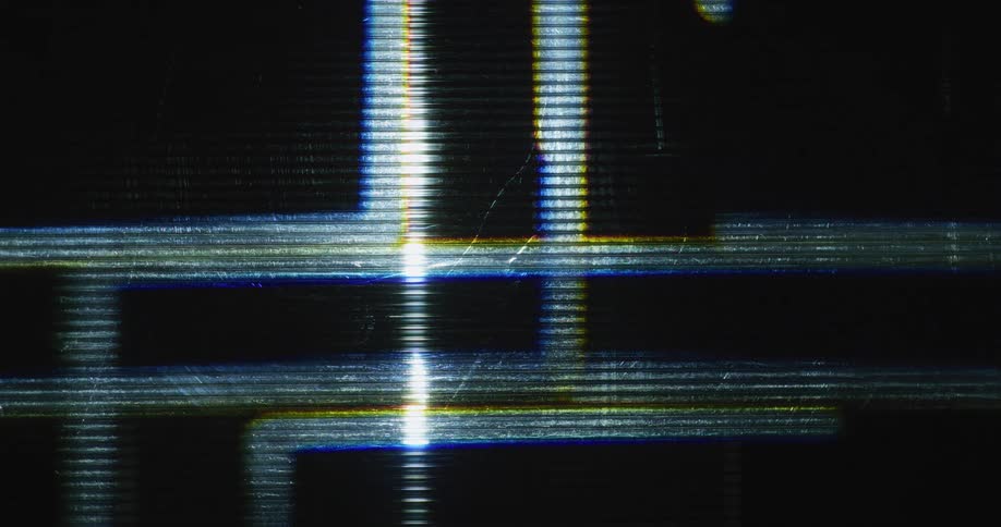 Geometric moving lines of light flash and flare against a black background