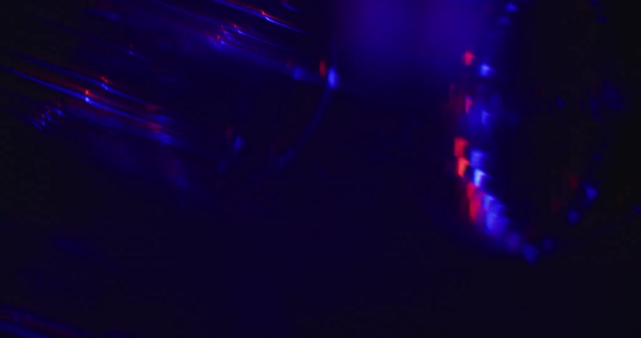 Blue and red lights flare and flash over a dark background