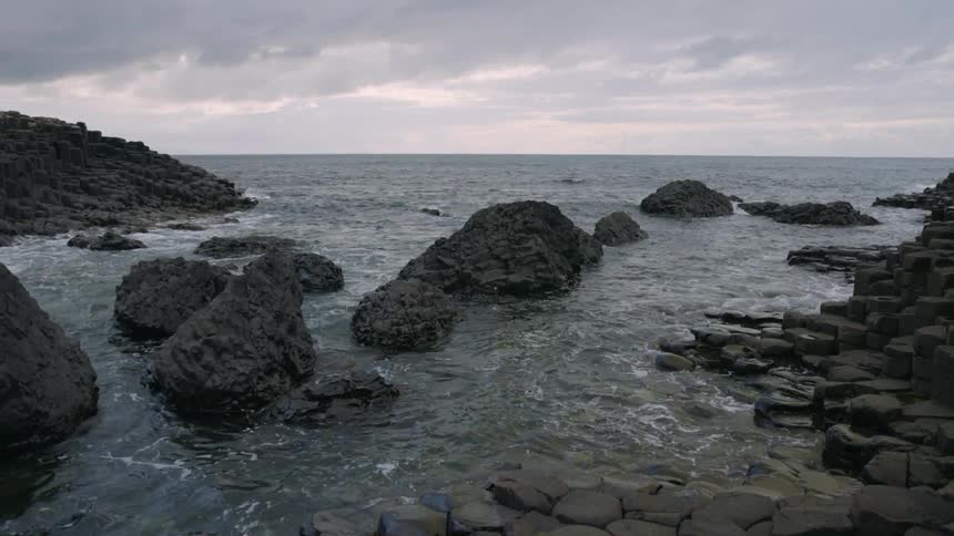 Small ocean waves gently wash upon a rocky coast line