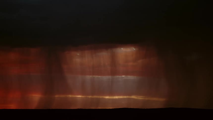 A heavy lightning storm cutting through a red sky