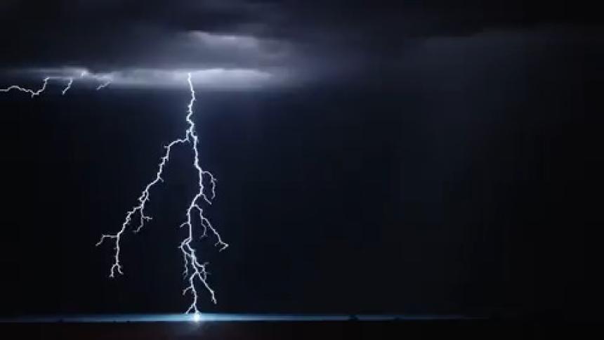 Flashes of bright lightning illuminate a stormy night sky