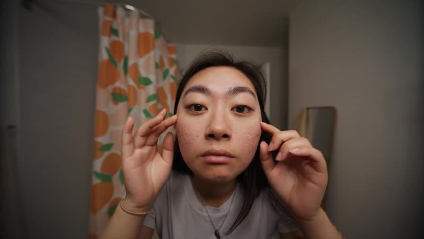 A young woman looking at her own face from different angles and in many ways