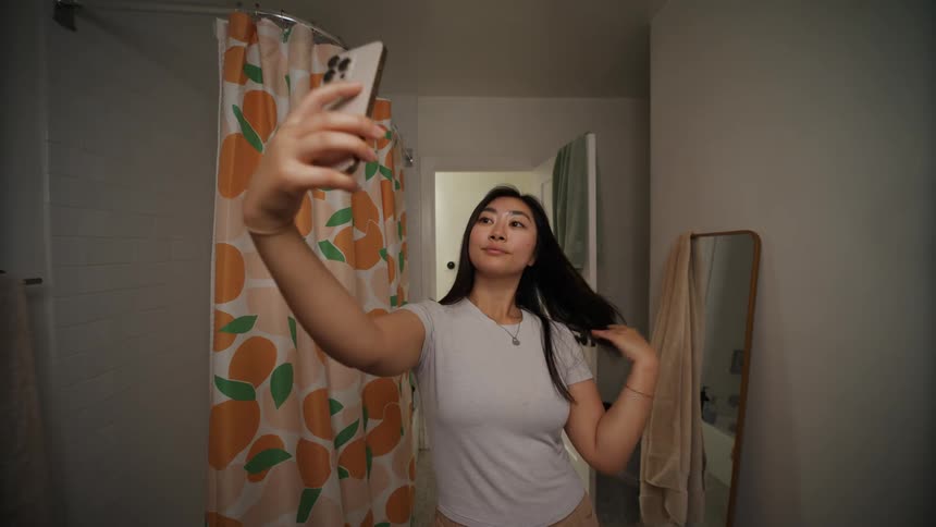 Woman taking photo with smartphone in bathroom