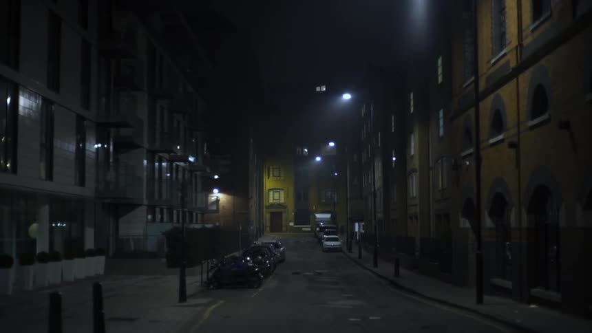 Cars are parked on a quiet street at night