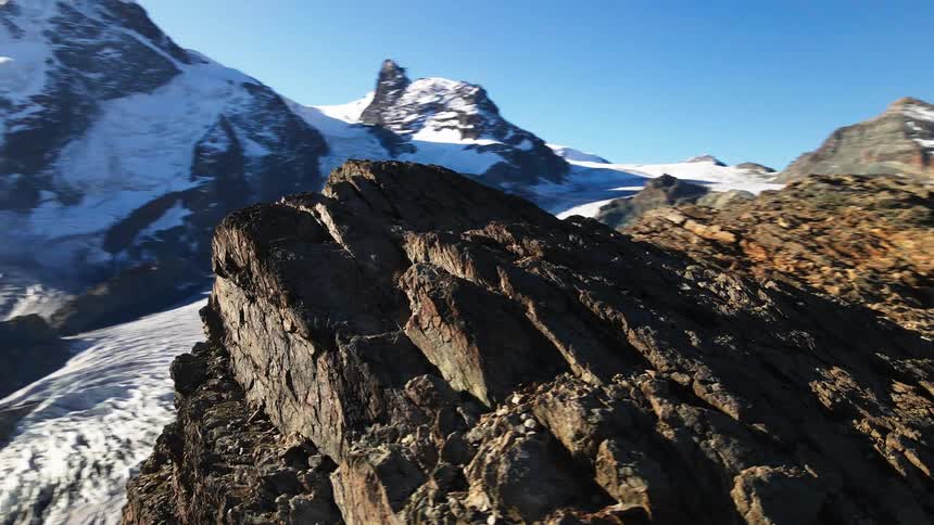Glacier separates stone peak from snow covered mountain