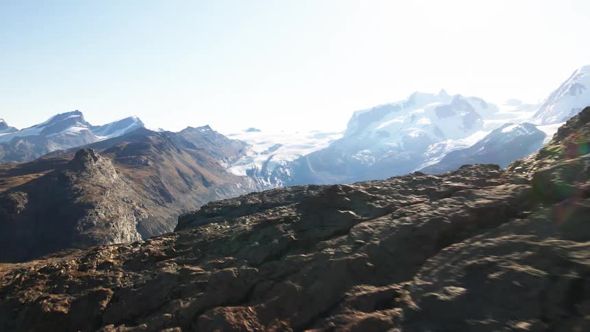 An aerial view of a large mountain range with some snow capped mountains