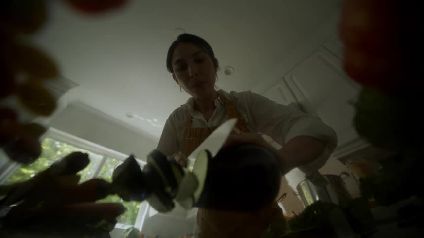 Woman smiles while slicing vegetables with a knife