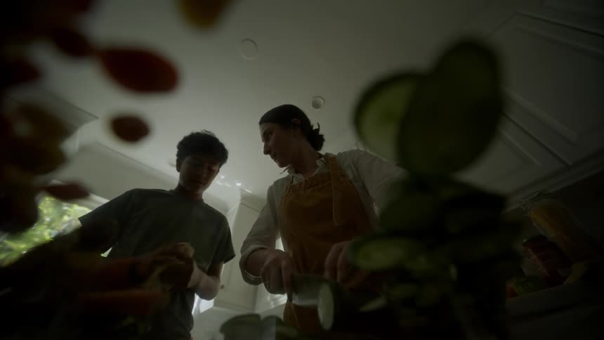A mother and son cooking and preparing food in the kitchen together