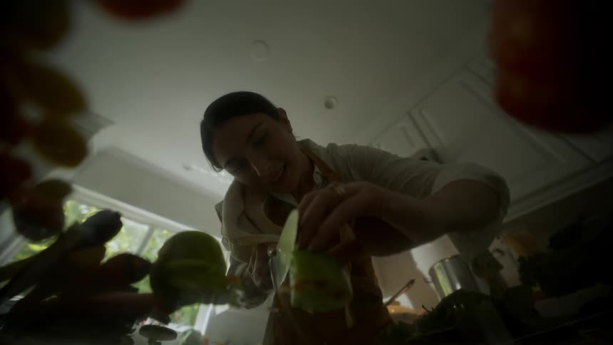 A woman cutting something with a knife in the kitchen