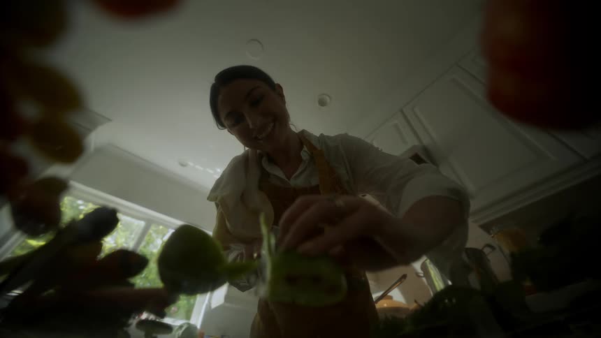 A woman inside the kitchen cutting fruits