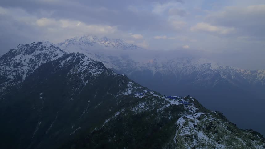 Snow is settled upon the top of an extensive mountain range