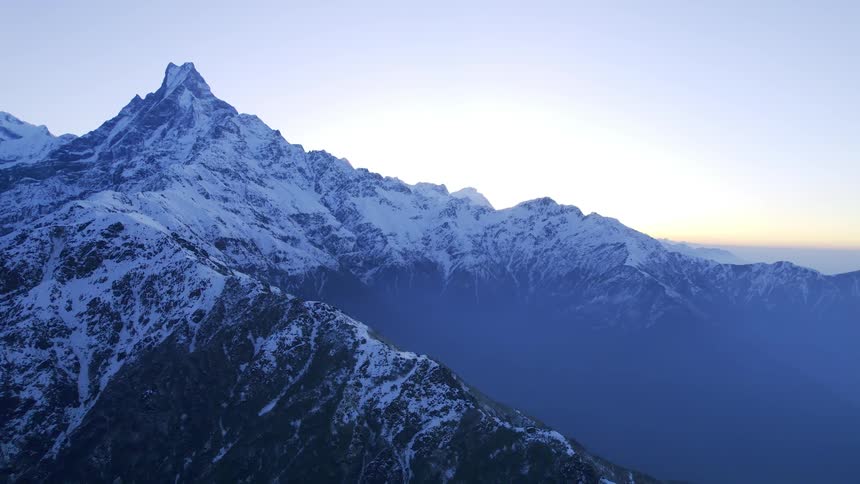 An aerial view of icy mountain peaks in the late afternoon