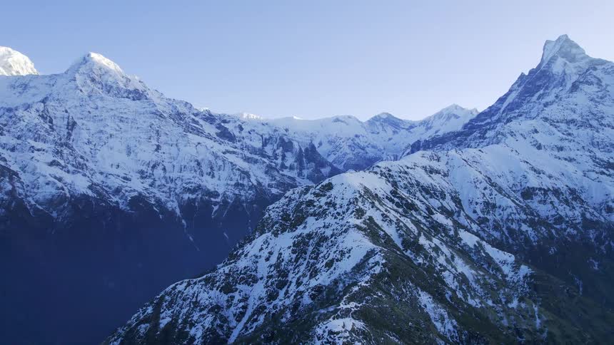 An aerial view of the peak of two icy mountains