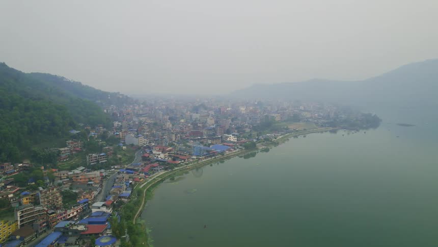 The city is on the shore of the foggy water