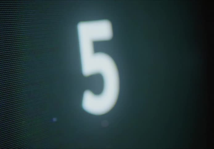 An extreme close up of a screen with numbers counting upward on the pixelated screen