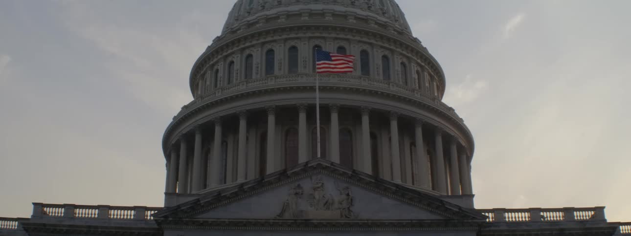 The american flag flies in front of the monument