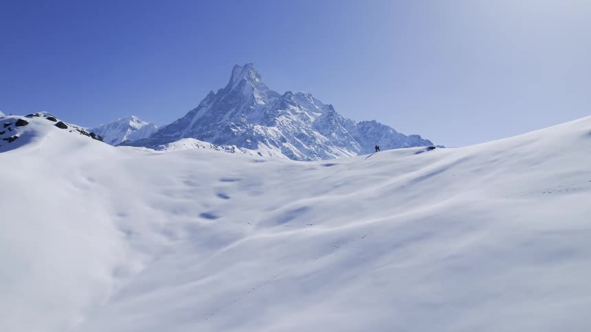 A landscape of a snowcovered mountain on a day with blue skies and sunshine