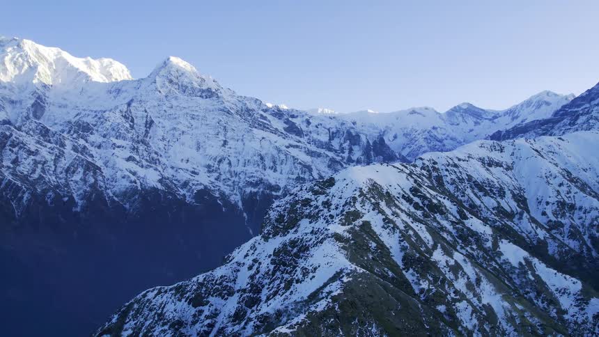An aerial of snow covered mountain peaks covering the landscape