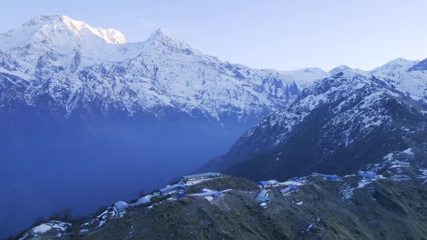 A large snowy mountain range with a campsite in the center