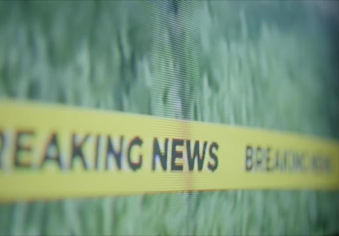 Close up of television screen displaying breaking news