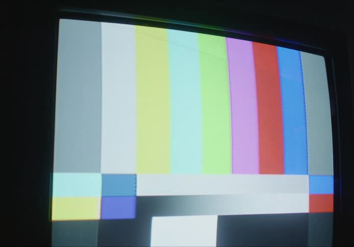 Vintage tv set turned on indoors displaying colored bars on the screen