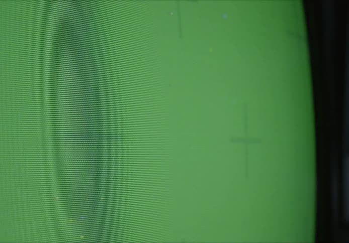A close up of a television screen with a green screen across it