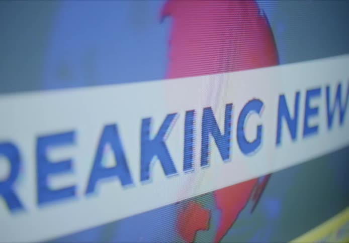 Close up of television screen with breaking news displaying