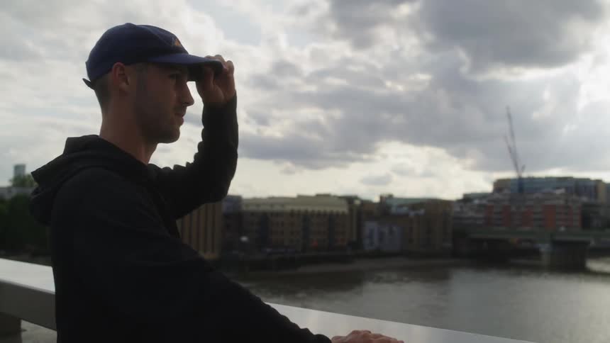 A man is looking out over the London bridge