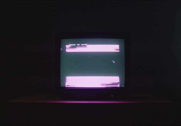 A broken television stands as a silent monolith in the dimly lit room its dark screen echoing the quiet desolation surrounding it