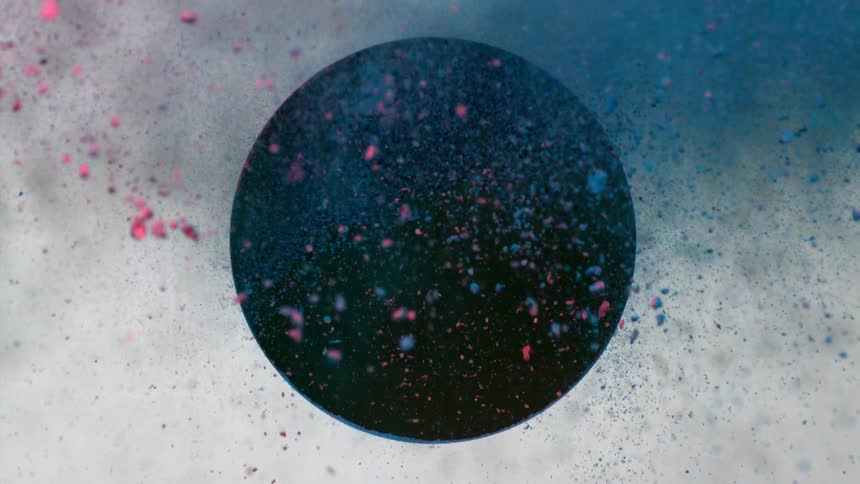 Blue and red dirt fly out of a black circle